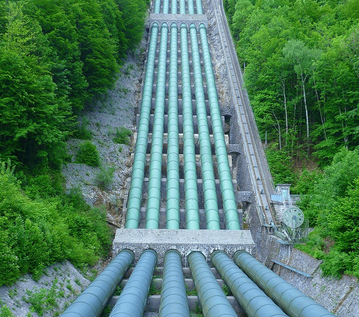 Large industrial pipes in a forest setting.